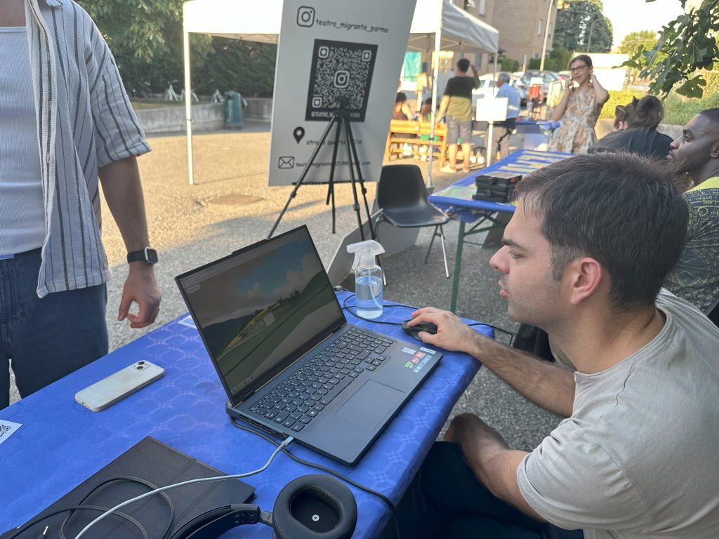 A teacher tries the Arte & Cultura experience on a laptop, sitting at an outdoor table