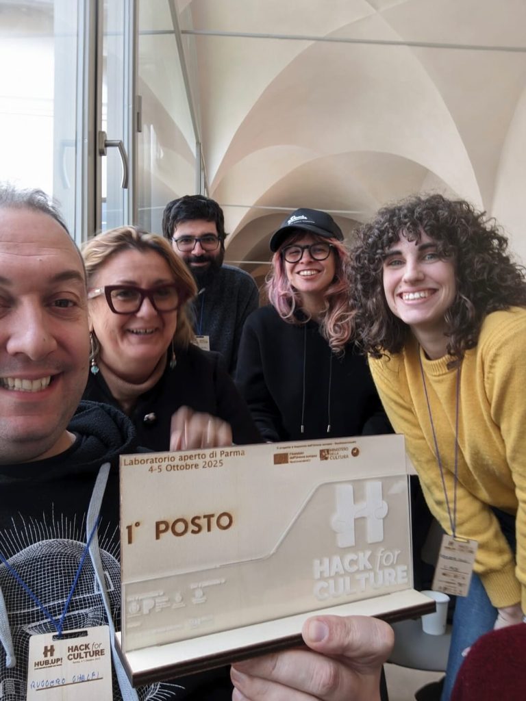 Four people with a first place placard, standing under a vaulted ceiling.
